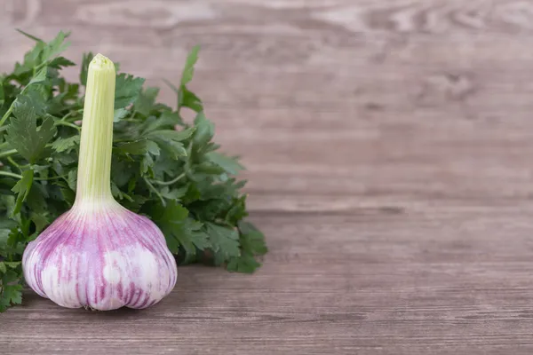 Knoblauch mit Petersilie auf hölzernem Hintergrund braun — Stockfoto