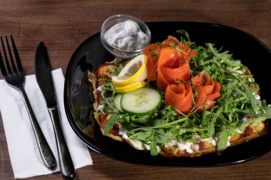 Lezzetli siyah bir kâsede somon salatası..