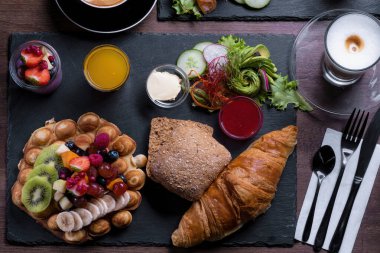 Kırsal ahşap masada iki kişilik kahvaltı ya da brunch seti.