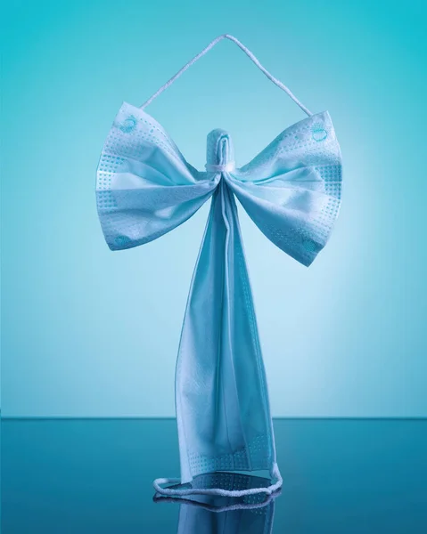 Protection face mask in the form of an angel on a blue background — Zdjęcie stockowe