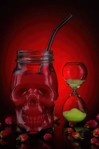 Red juice in skull jars on a red background.