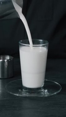 Barista dökülen süt sıcak kahve ve kapuçino kafede köpük yapım yakın çekim,