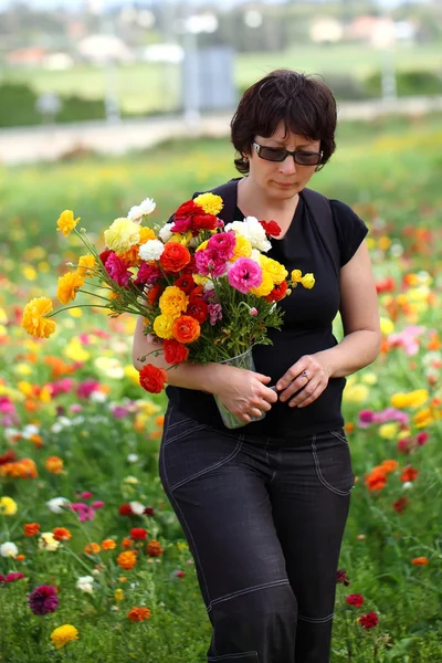 Frau pflückt Blumen — Stockfoto