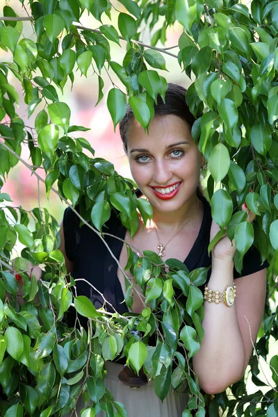 Frau posiert in der Nähe eines grünen Baumes — Stockfoto