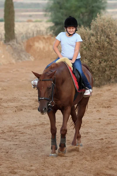 Menina está montando um cavalo — Fotografia de Stock