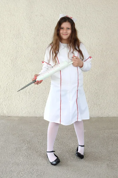 Klein meisje in verpleegkundigen kostuum — Stockfoto