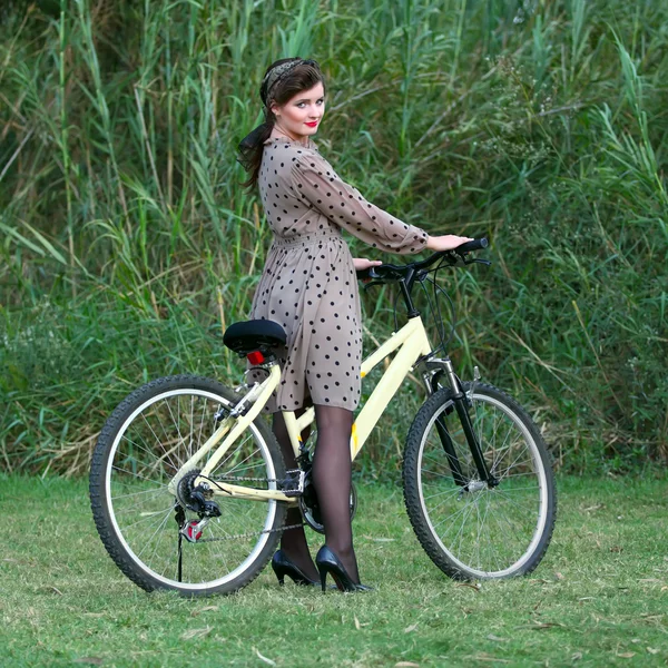 Young woman posing on a bike — Stock Photo, Image