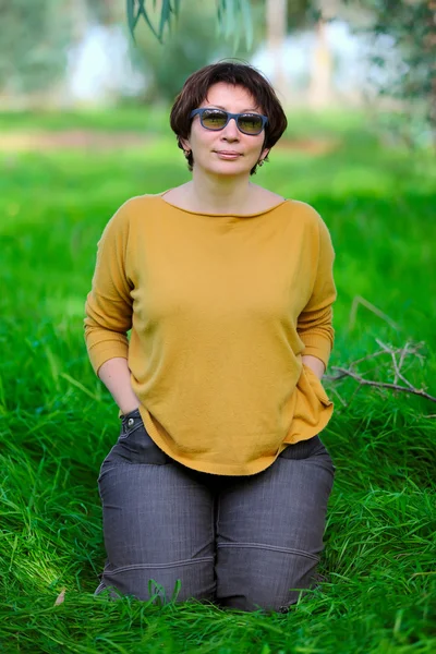 Woman sitting on green grass — Stock Photo, Image