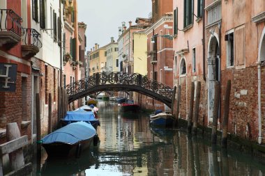 Venedik, İtalya. Balıkçı tekneleri ve eski evleri olan geleneksel dar kanal caddesi..