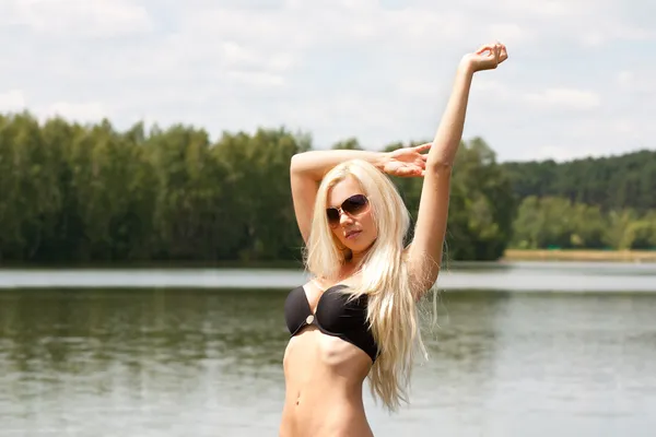 Unga vackra blonda flickan vid sjön — Stockfoto