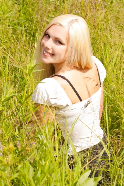 Menina loira bonita na grama — Fotografia de Stock