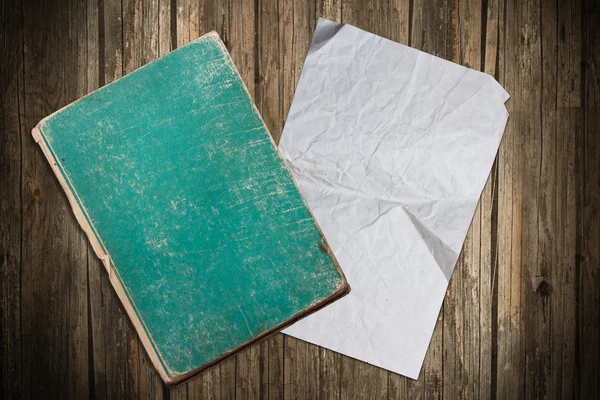 Libro viejo descolorido y papel sobre un fondo de madera — Foto de Stock