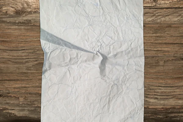 Винтажный скомканный лист бумаги на дереве — стоковое фото