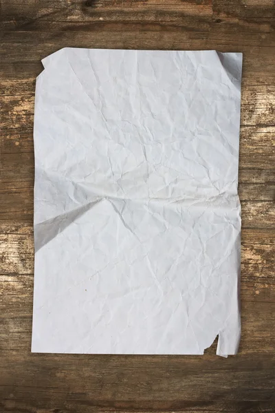 Hoja de papel vieja envejecida sobre un fondo de madera — Foto de Stock