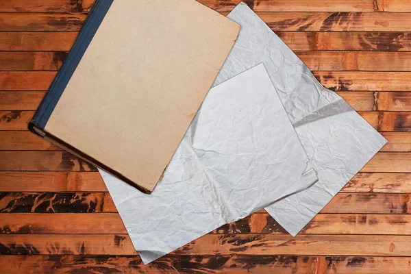 Винтажная книга и бумаги на деревянном фоне — стоковое фото