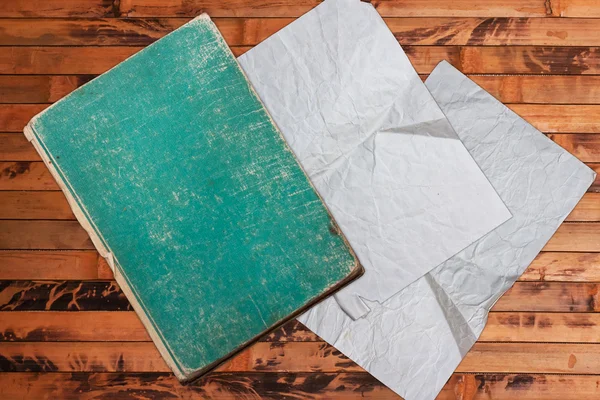 Винтажная книга и бумага на деревянном фоне — стоковое фото