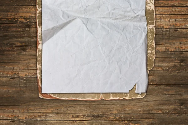 Gescheurde oud papier op een houten achtergrond — Stockfoto