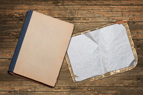 Book and vintage paper on a wooden background — Stock Photo, Image