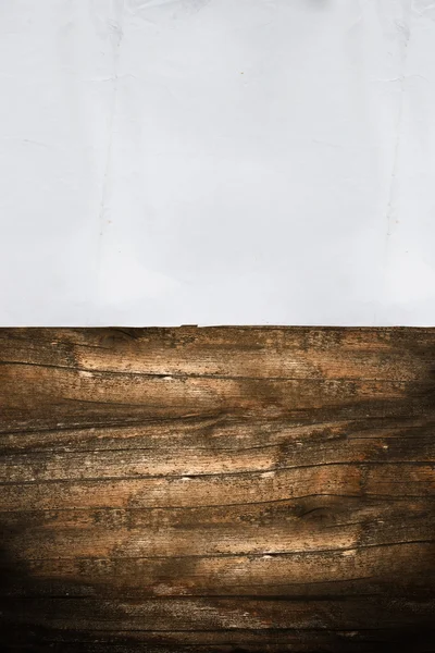 Folha de papel enrugada em um fundo de madeira escura — Fotografia de Stock