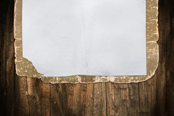 Papel danificado vazio em um fundo de madeira — Fotografia de Stock