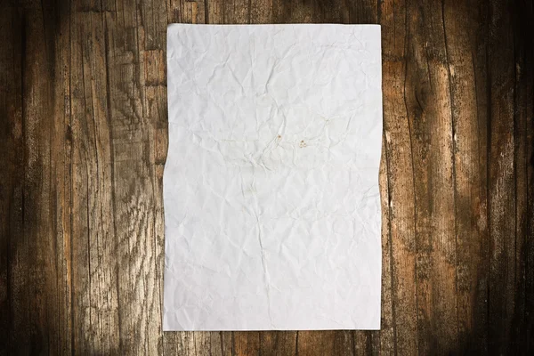 Folha de papel vazia enrugada em madeira — Fotografia de Stock