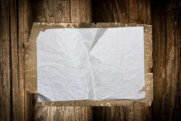 Gescheurd papier blad een houten achtergrond — Stockfoto
