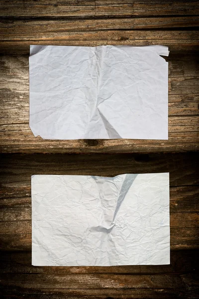 Folhas de papel enrugadas em um fundo de madeira — Fotografia de Stock