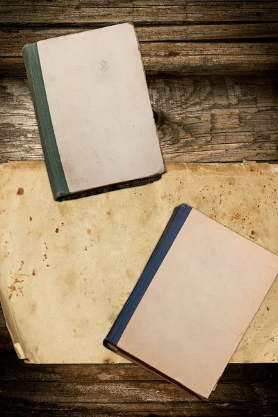 Libros antiguos y papel en blanco sobre fondo de madera — Foto de Stock