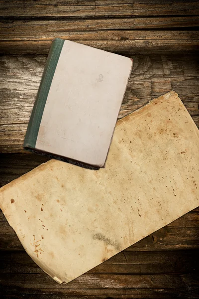 Libro y papel descoloridos sobre un fondo de madera — Foto de Stock