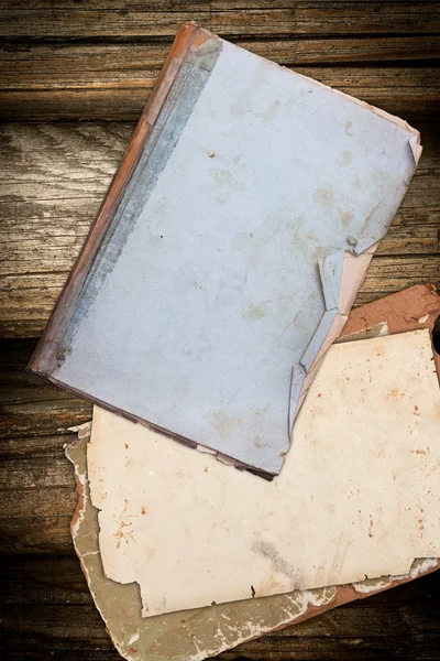 Livre et papier déchirés sur un fond en bois — Photo