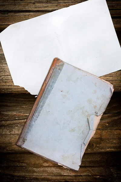 Damaged book and paper on a wooden background — Stock Photo, Image