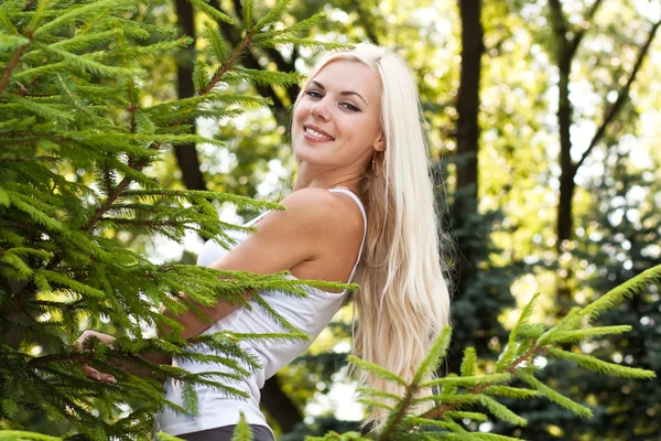 Усміхнена блондинка в парку — стокове фото