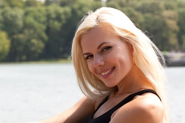 Lächelnde blonde Dame am See — Stockfoto