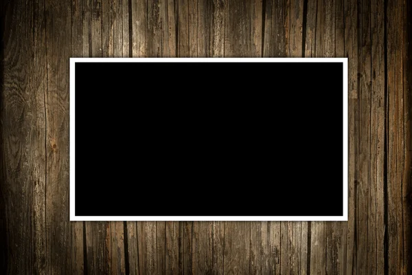 Cornice fotografica scura vuota su uno sfondo di legno — Foto Stock