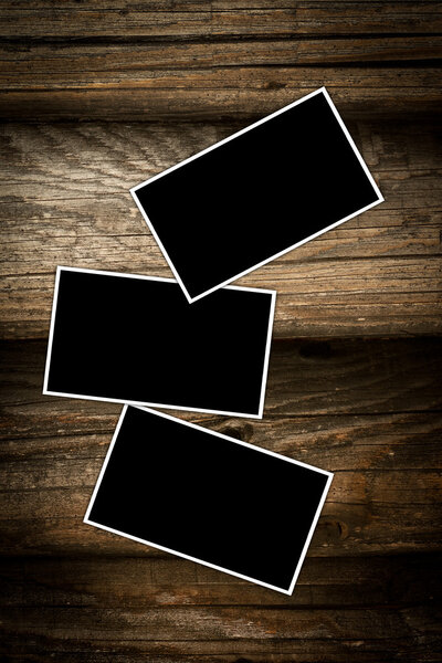 Empty photo frames on a wooden background