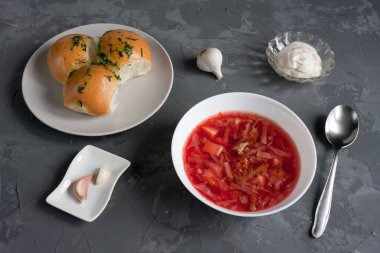 Ulusal Slav mutfağı borç. Geleneksel Ukrayna mutfağının ilk ana yemeği donutlu kırmızı borsch 'tur. Ekşi krema ve sarımsaklı. Masa gri..