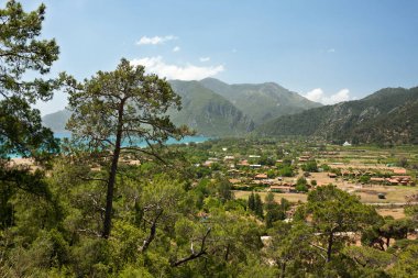 Akdeniz kıyısındaki dağlarla çevrili Cirali köyüne bakan resimli manzara. Lycian Yolu boyunca yürüyorum. Açık bir bahar günü. Türkiye, Antalya, Kemer.