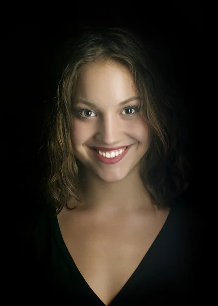 Retrato de uma menina bonita em um fundo preto — Fotografia de Stock