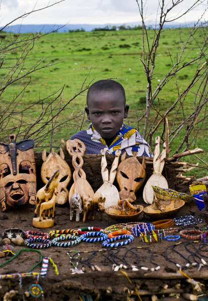 child sells souvenirs at Maasai Mara, Kenya