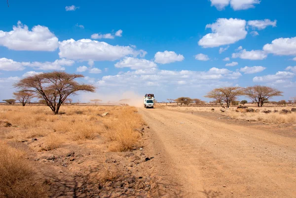 Auto s lidmi v africké poušti — Stock fotografie