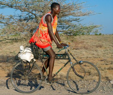 geleneksel giysiler içinde Afrika adam bisiklet sürmek