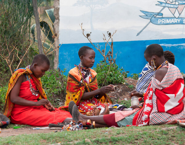 Maasai women makes traditional necklace