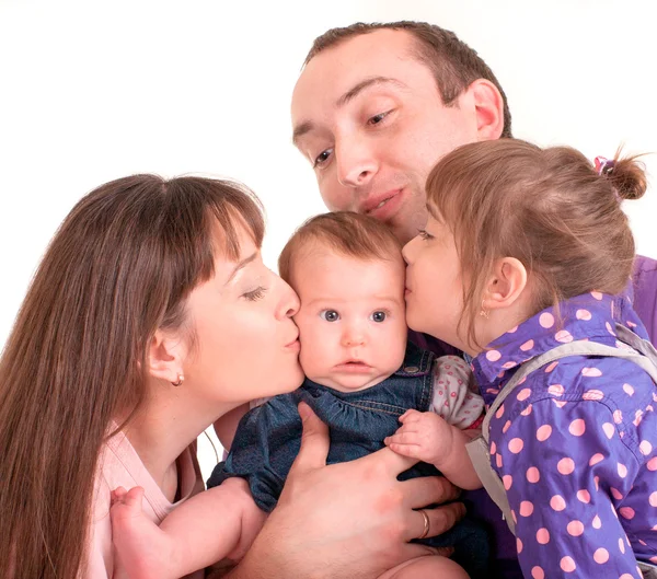 Pai e mãe beijando seu bebê sobre fundo branco — Fotografia de Stock