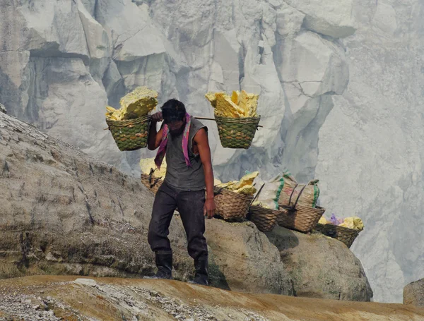 El trabajador lleva azufre dentro del cráter en el volcán Ijen, Indonesia — Foto de Stock