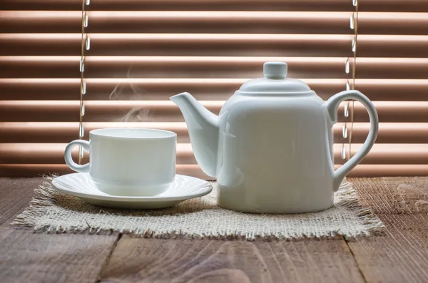 Tea cup with teapot on old wooden table — Stock Photo, Image