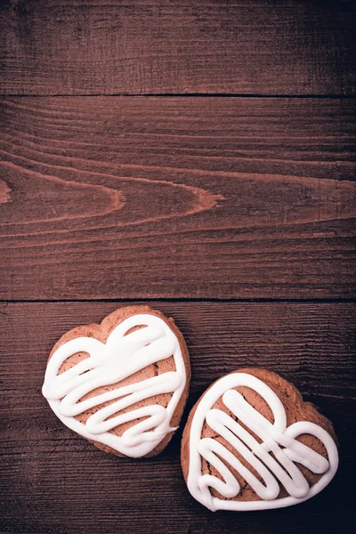 Homemade ginger cookies heart shaped over wooden table. — Stock Photo, Image