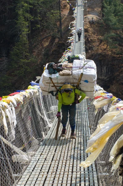 Träger tragen schwere Last im Himalaya — Stockfoto