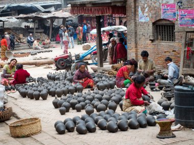 Nepalese people working in the her pottery workshop clipart