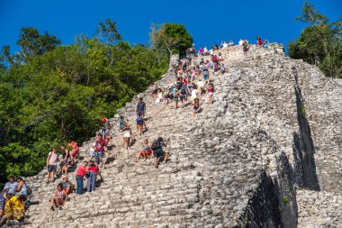 Coba, Meksika - 12.23.2020: Meksika 'nın Coba-Antik Maya kenti. Yucatan Yarımadası arkeolojik alanı olan Coba' daki Nohoch Mul 'un tepesine tırmanan turistler.