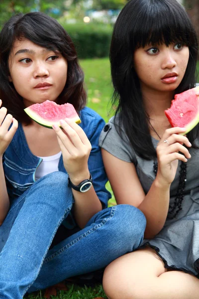 Δύο όμορφες χαμογελώντας νεαρά κορίτσια που τρώνε, καρπούζι — Φωτογραφία Αρχείου